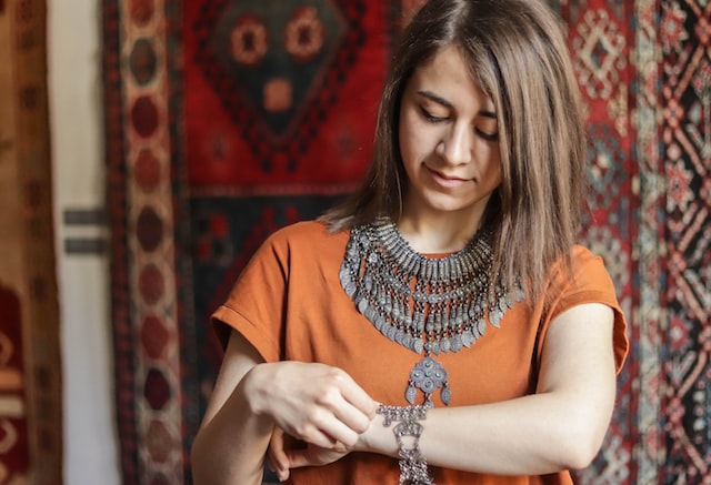 a woman puts on jewelry