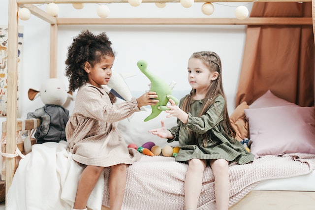 girls-playing-a-green-plush-toys