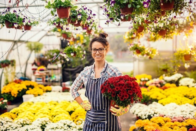 smiling florist holding pot with flowers