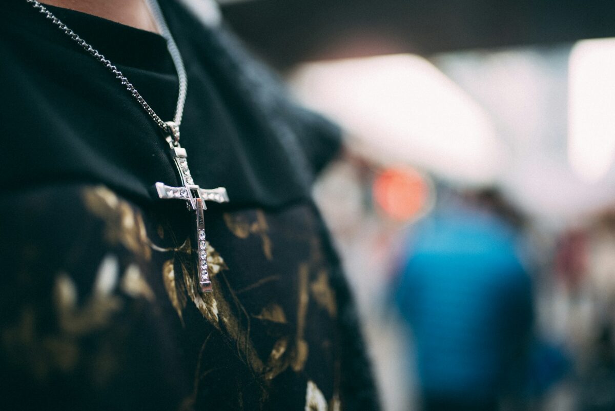 a-person-wearing-a-black-shirt-and-a-cross-necklace